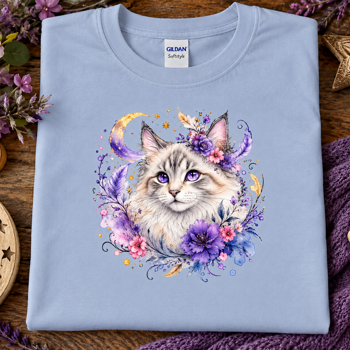 A light blue t-shirt with a silver tabby cat wrapped in colorful flowers graphic.