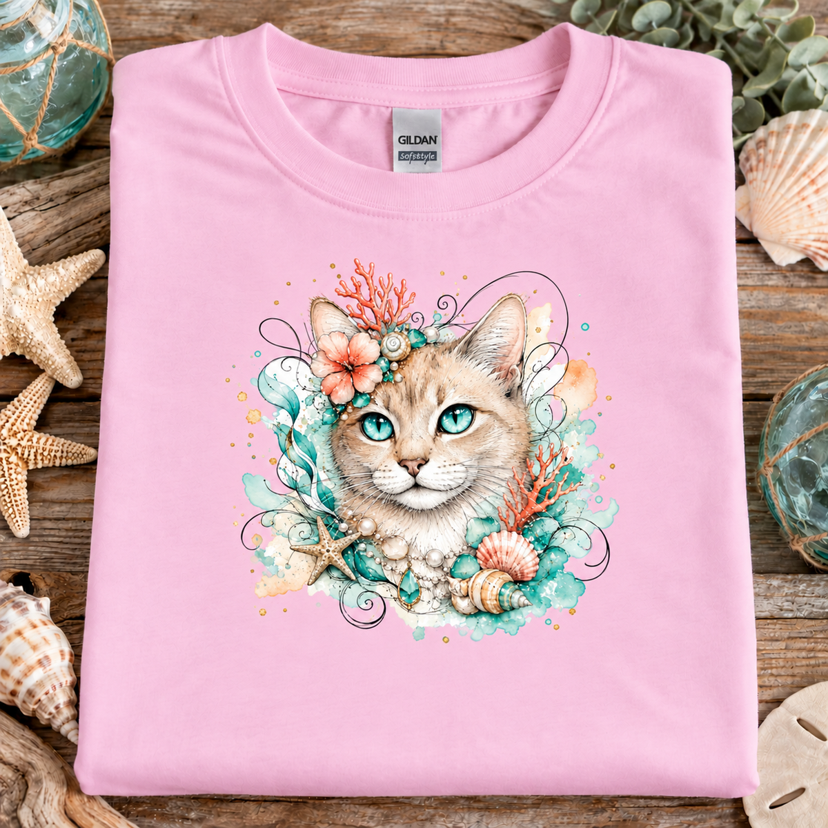 A fan candy pink colored t-shirt with a tan tabby cat surrounded by seashells