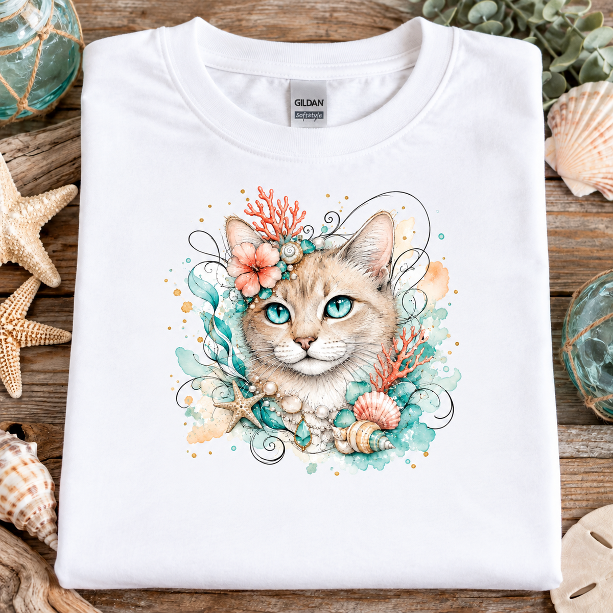  A white t-shirt with a tan tabby cat surrounded by seashells