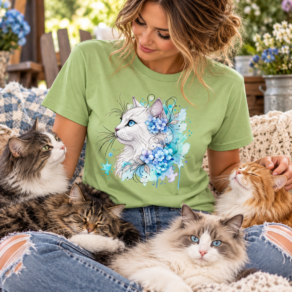 a woman wearing a pistachio colored t-shirt with a white cat surrounded by flowers graphic