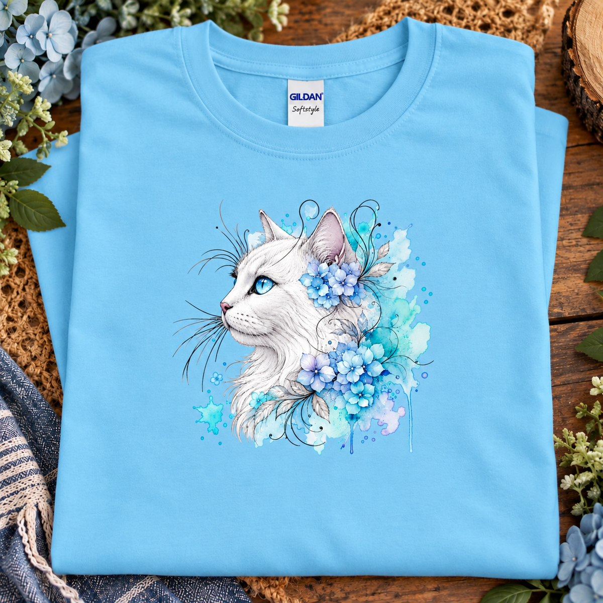 A sky Blue colored T-Shirt with a white cat surrounded by flowers
