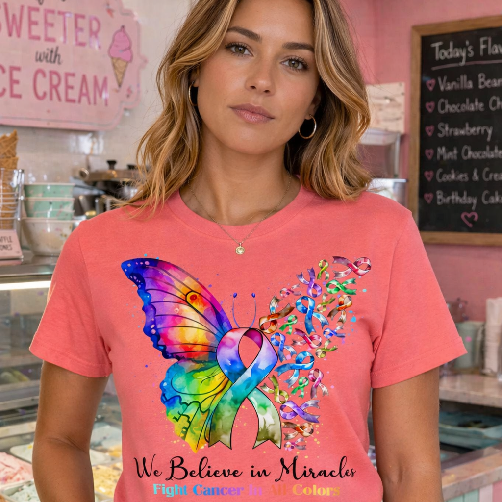 Woman wearing a pink t-shirt with a colorful butterfly and ribbon design in a bakery.