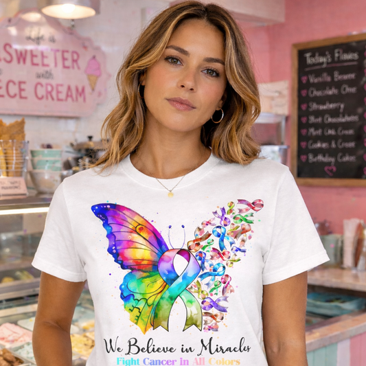 Woman wearing a white t-shirt with a colorful butterfly design and text in a bakery setting