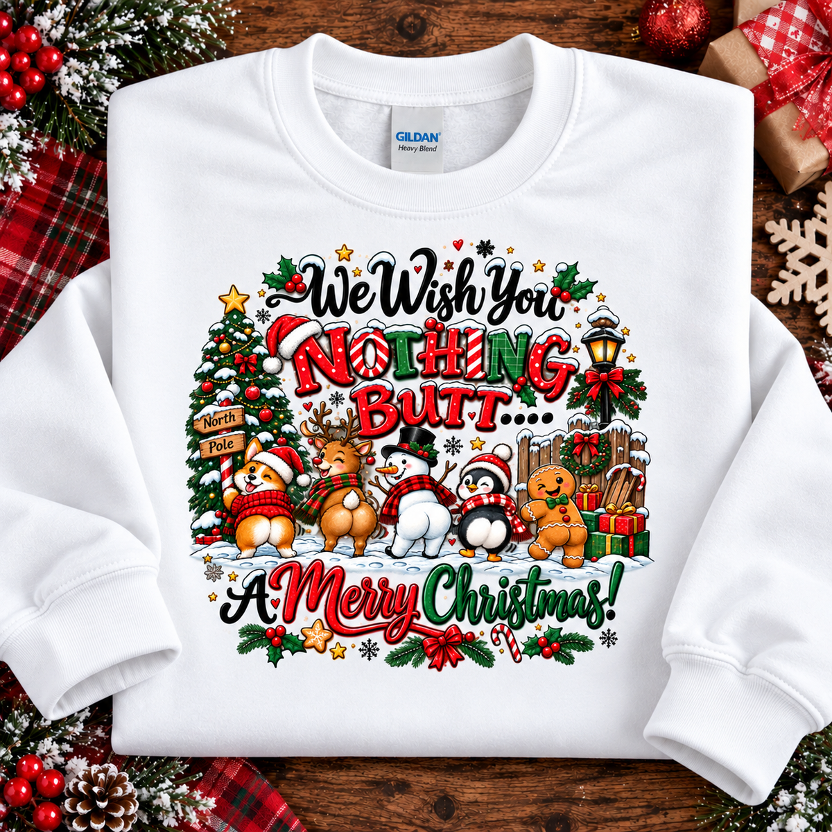 A white crewneck sweatshirt laid flat on a rustic wooden surface, surrounded by Christmas-themed props like a red plaid scarf, pinecones, and a wrapped gift. The sweatshirt features a colorful graphic with the text 'We Wish You Nothing But.
