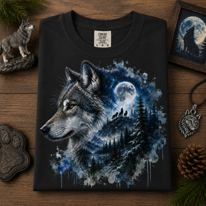 A black crewneck t-shirt with a detailed graphic of a wolf and a moonlit forest, laid flat on a wooden surface surrounded by wolf-themed props.