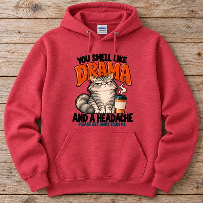 A heather scarlet red crewneck hoodie featuring a humorous graphic print of a grumpy cat next to a coffee cup, with the text 'YOU SMELL LIKE DRAMA AND A HEADACHE PLEASE GET AWAY FROM ME'. 