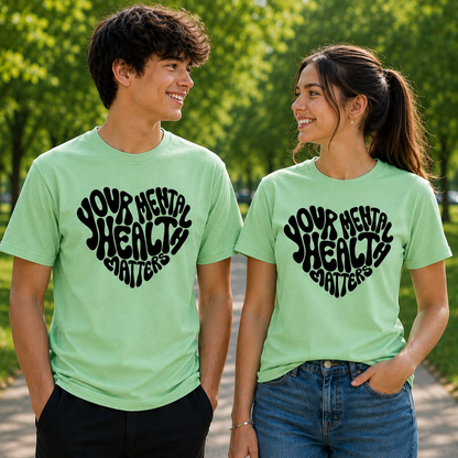 Two people wearing green t-shirts with 'Your Mental Health Matters' text in a park.