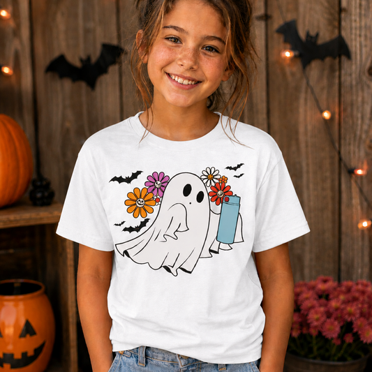Girl wearing a white t-shirt with a ghost graphic design with flowers and bats